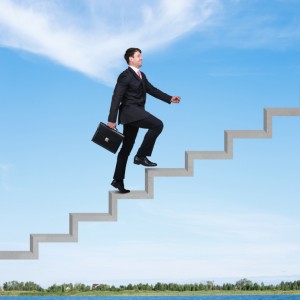 Image of confident businessman with briefcase walking upstairs ©istock.com/Dmitrii Kotin