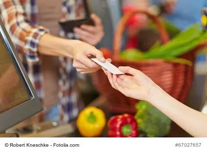Hand einer Kunding zeigt eine Kundenkarte an der Kasse im Supermarkt